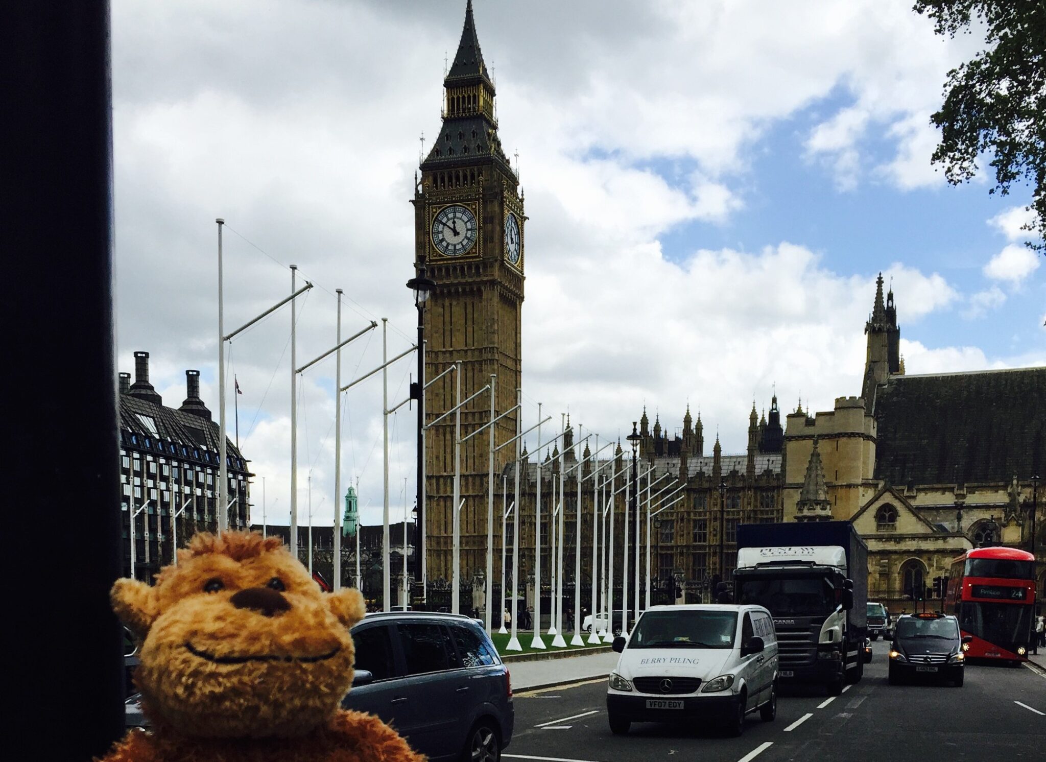 a stuffed animal in front of a clock tower