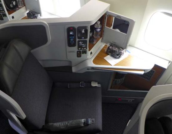 an airplane seat with a small table and a small shelf