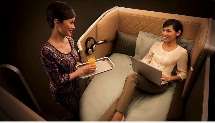 a woman holding a tray and a laptop