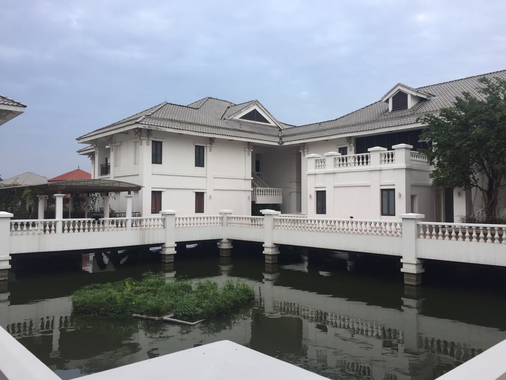 a white house with a bridge over water
