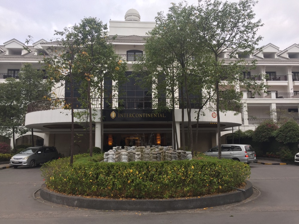 a building with trees and a fountain in front of it