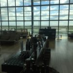 a room with a large window and a bar with bottles and glasses