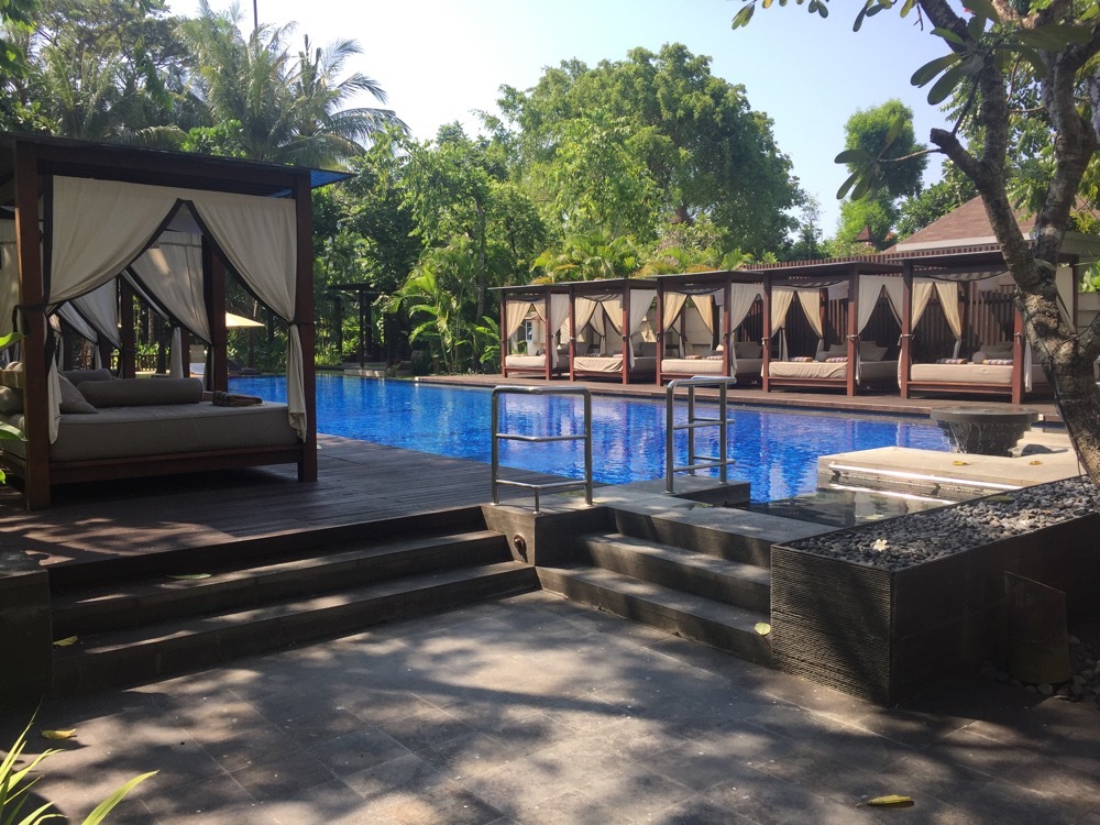 a pool with beds and a gazebo