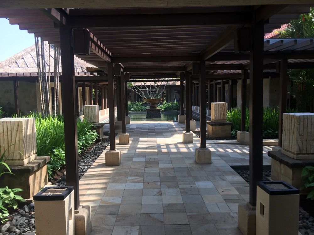 a walkway with a fountain and a fountain