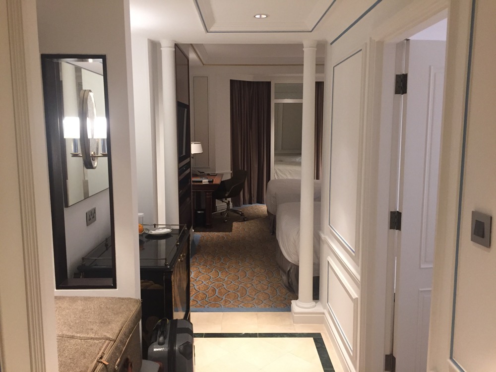 a hallway with a bed and a desk