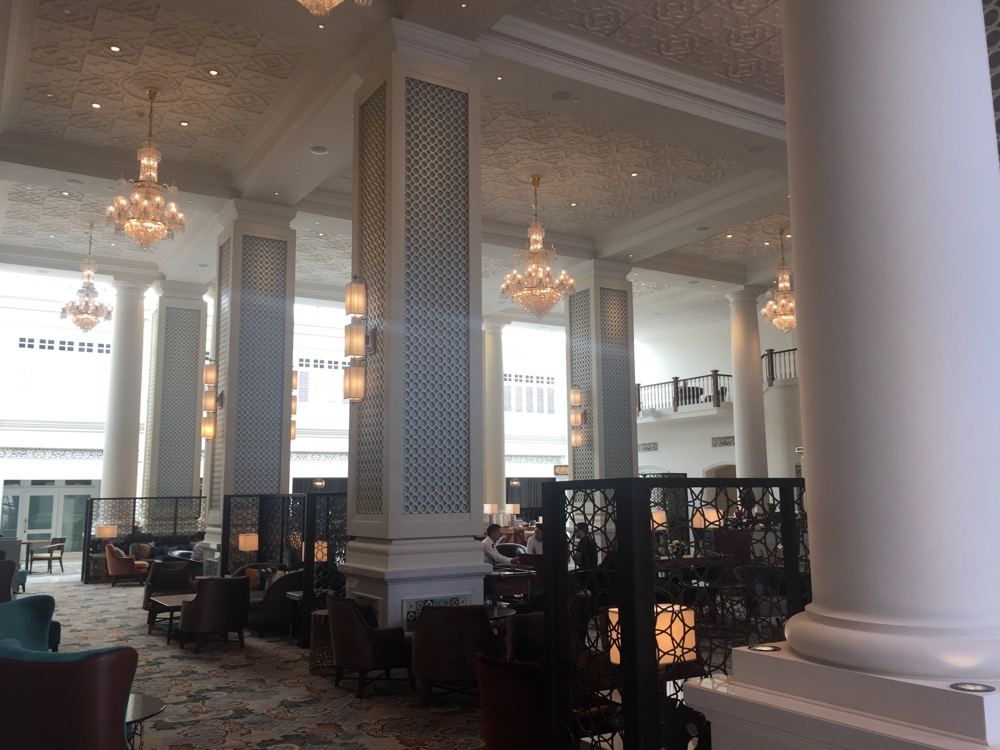 a large room with columns and chandeliers
