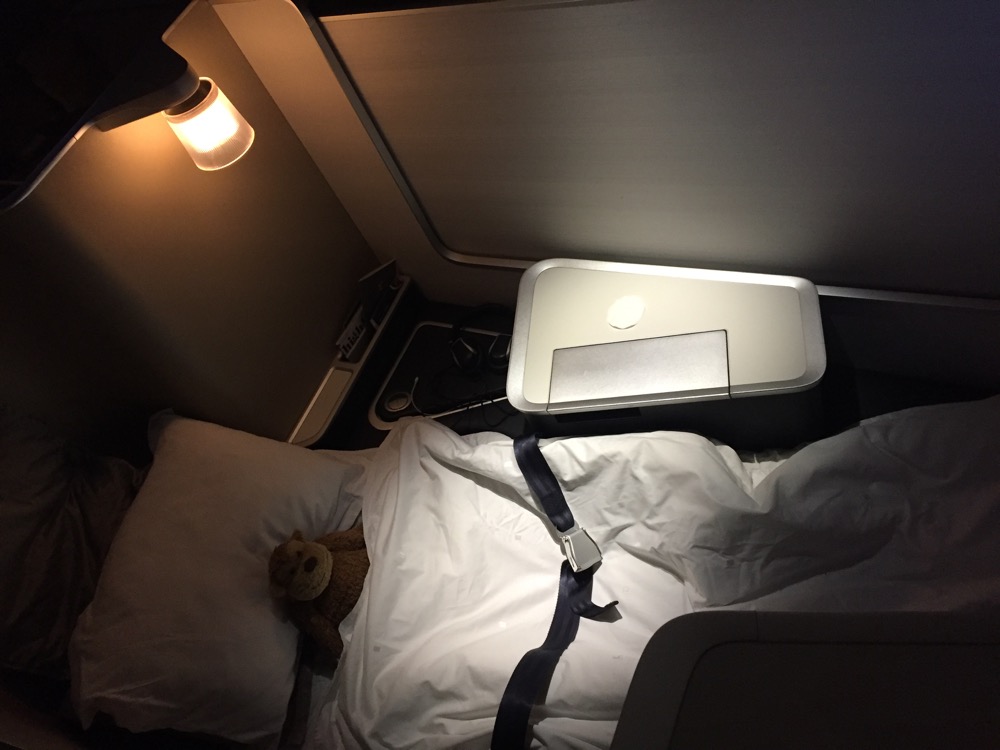a small bed with a teddy bear on it