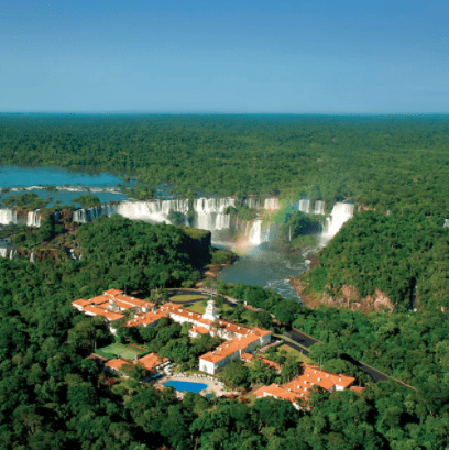 a building surrounded by trees and a waterfall