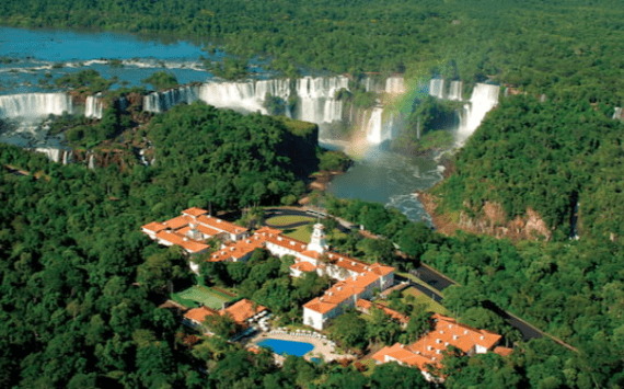 a building surrounded by trees and a waterfall