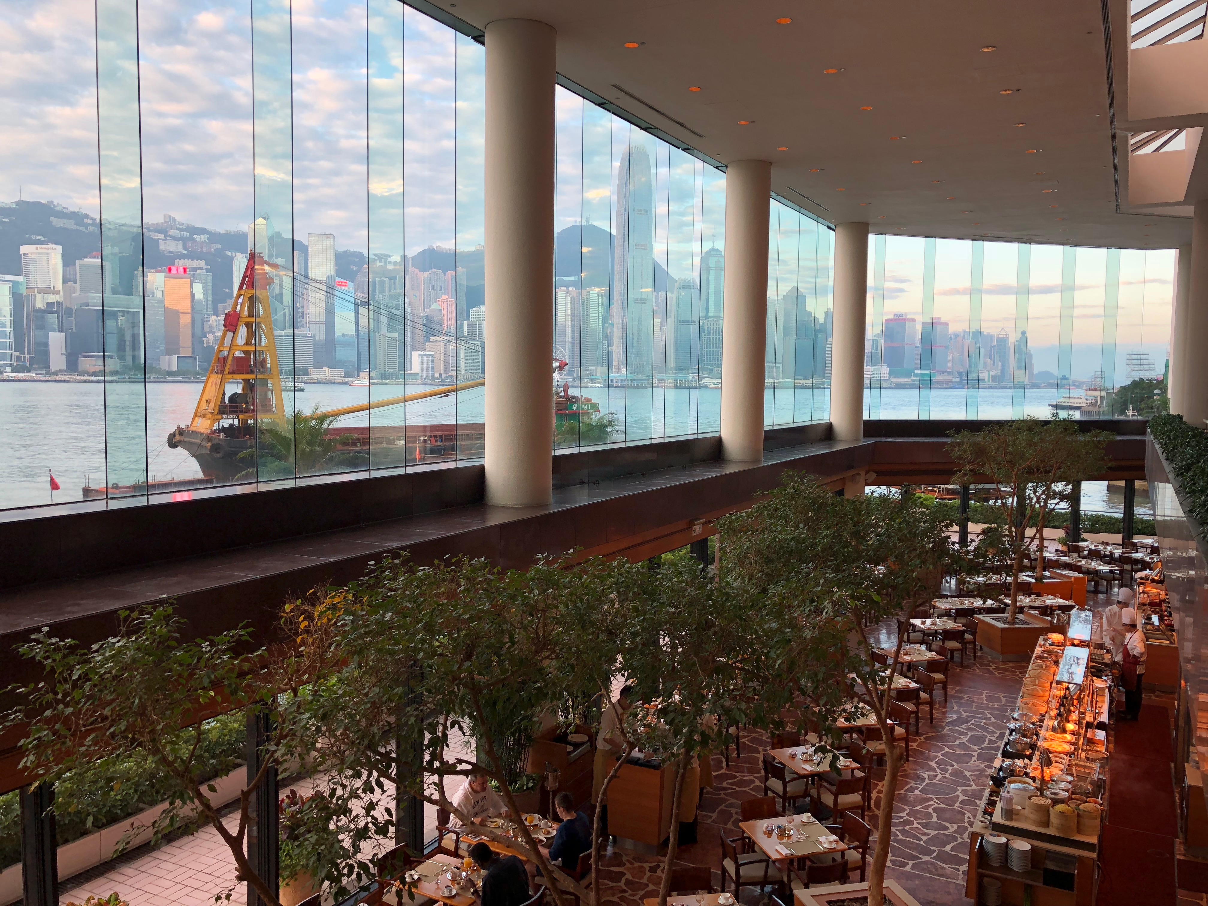 a large glass building with a large window and a city in the background