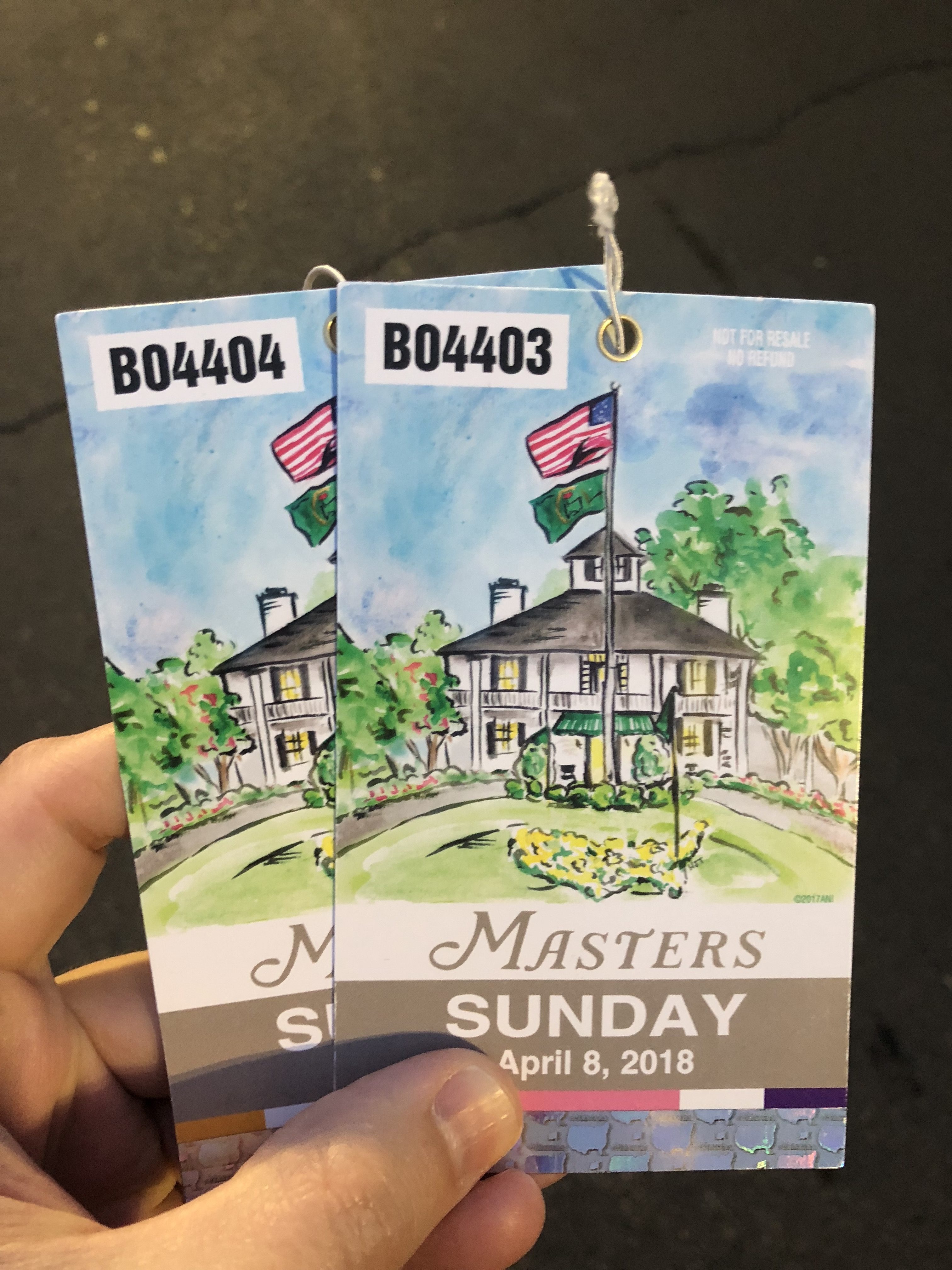 a hand holding a pair of tickets