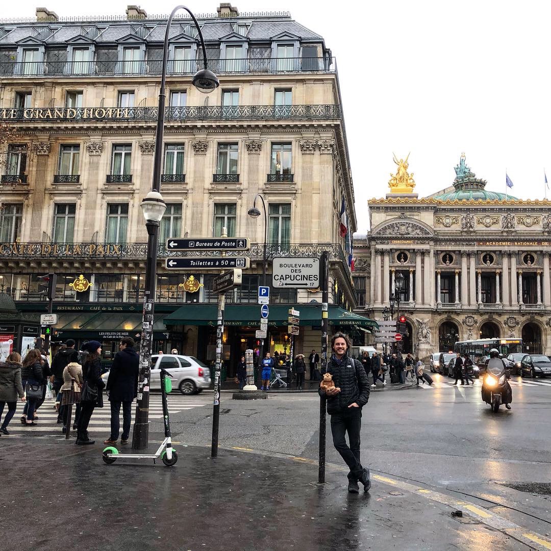 a man standing on a street corner in front of a building