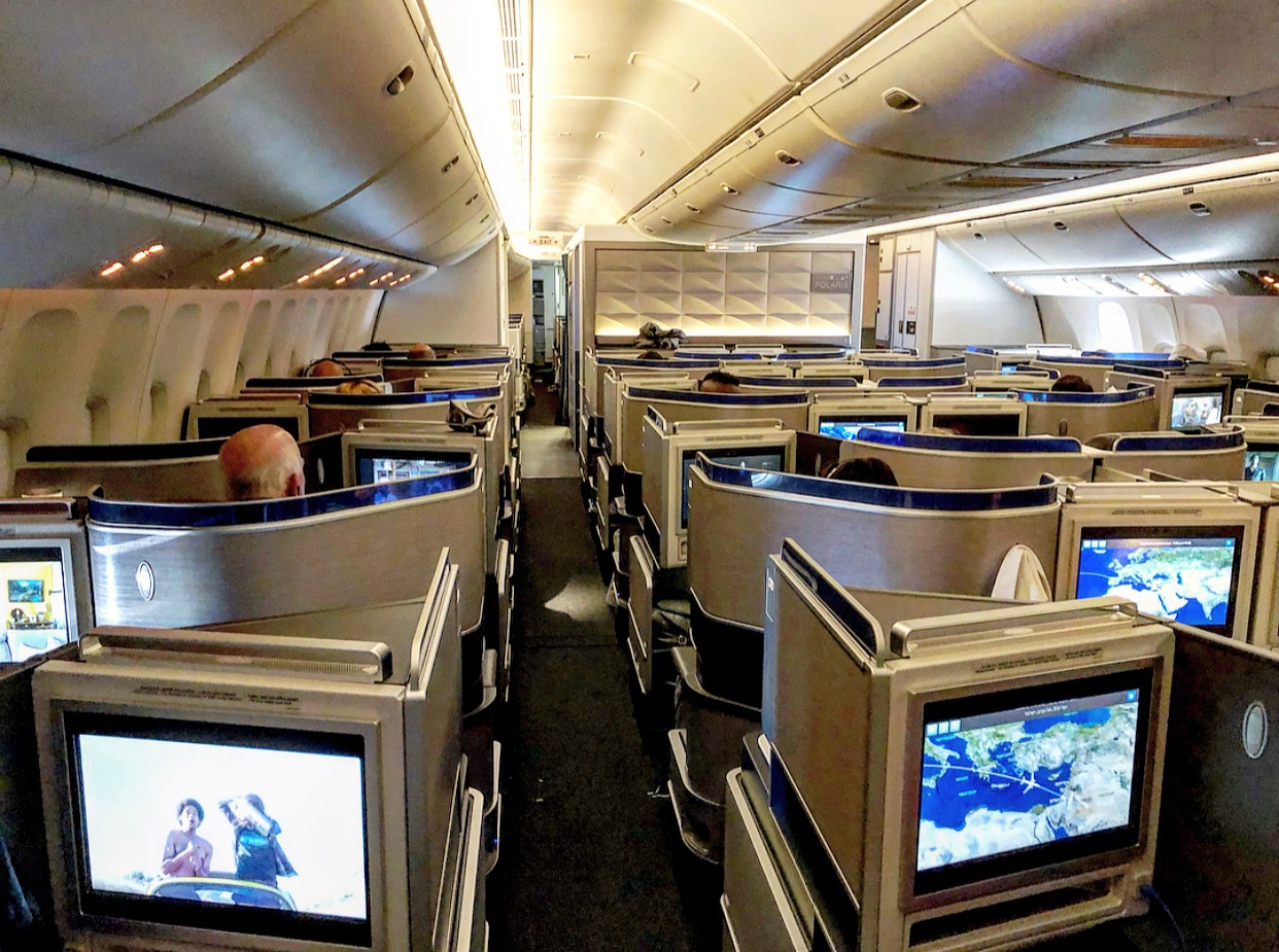 an airplane with rows of seats and monitors