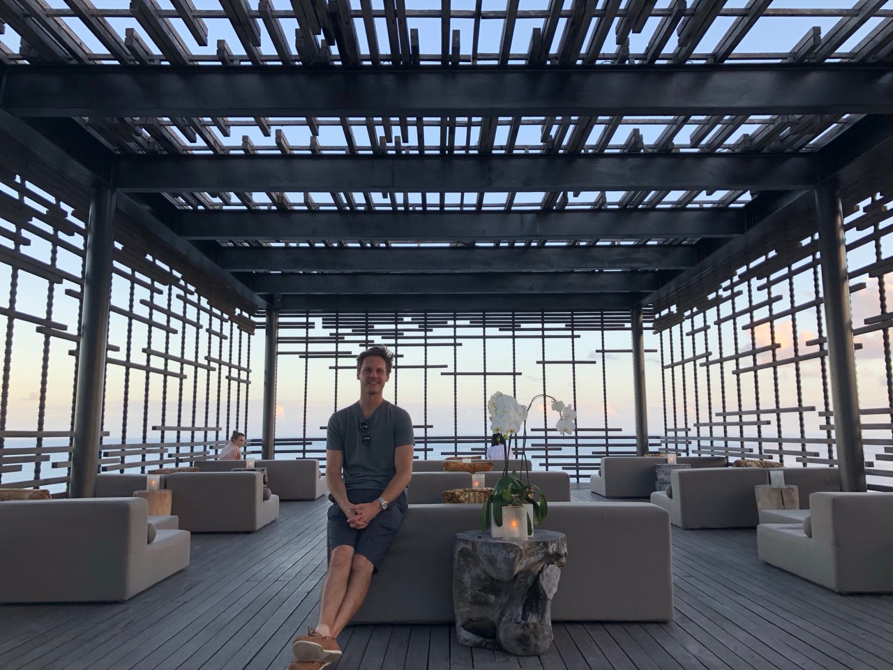 a man sitting on a bench in a room with a large window