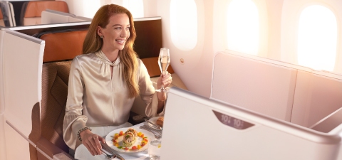 a woman sitting at a table with food and a glass of champagne