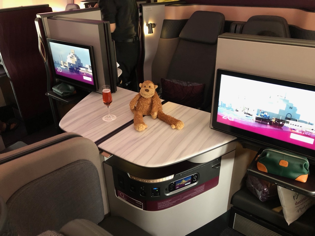 a stuffed animal on a table with computer screens