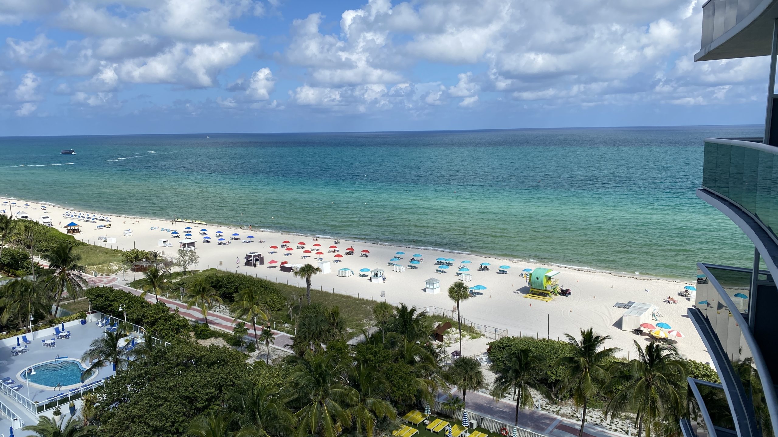 a beach with umbrellas and palm trees