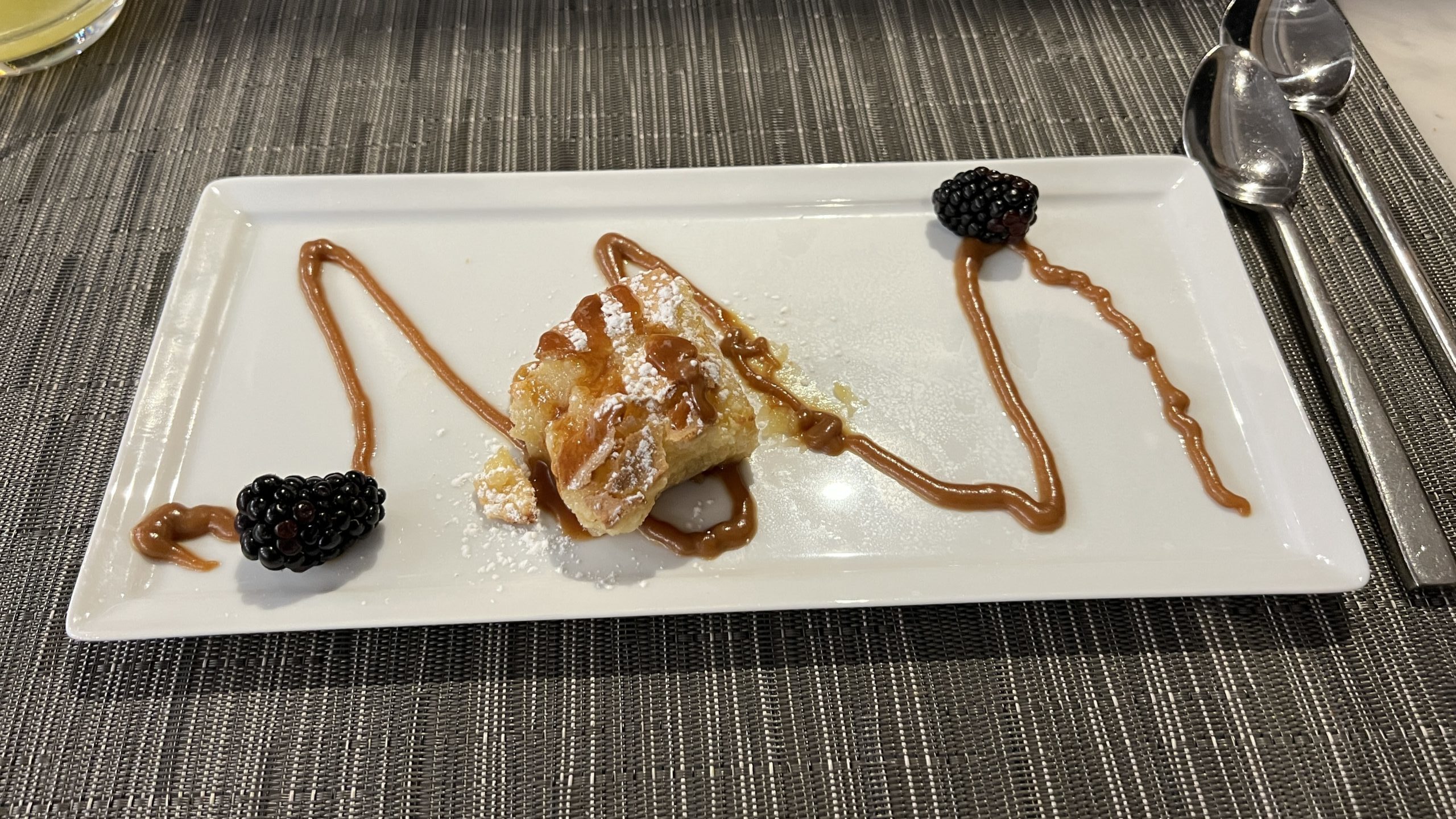 a plate of dessert with blackberries and syrup