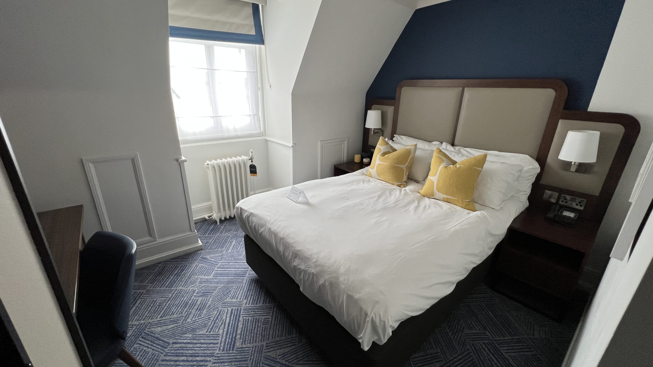 a bed with a white bed and yellow pillows