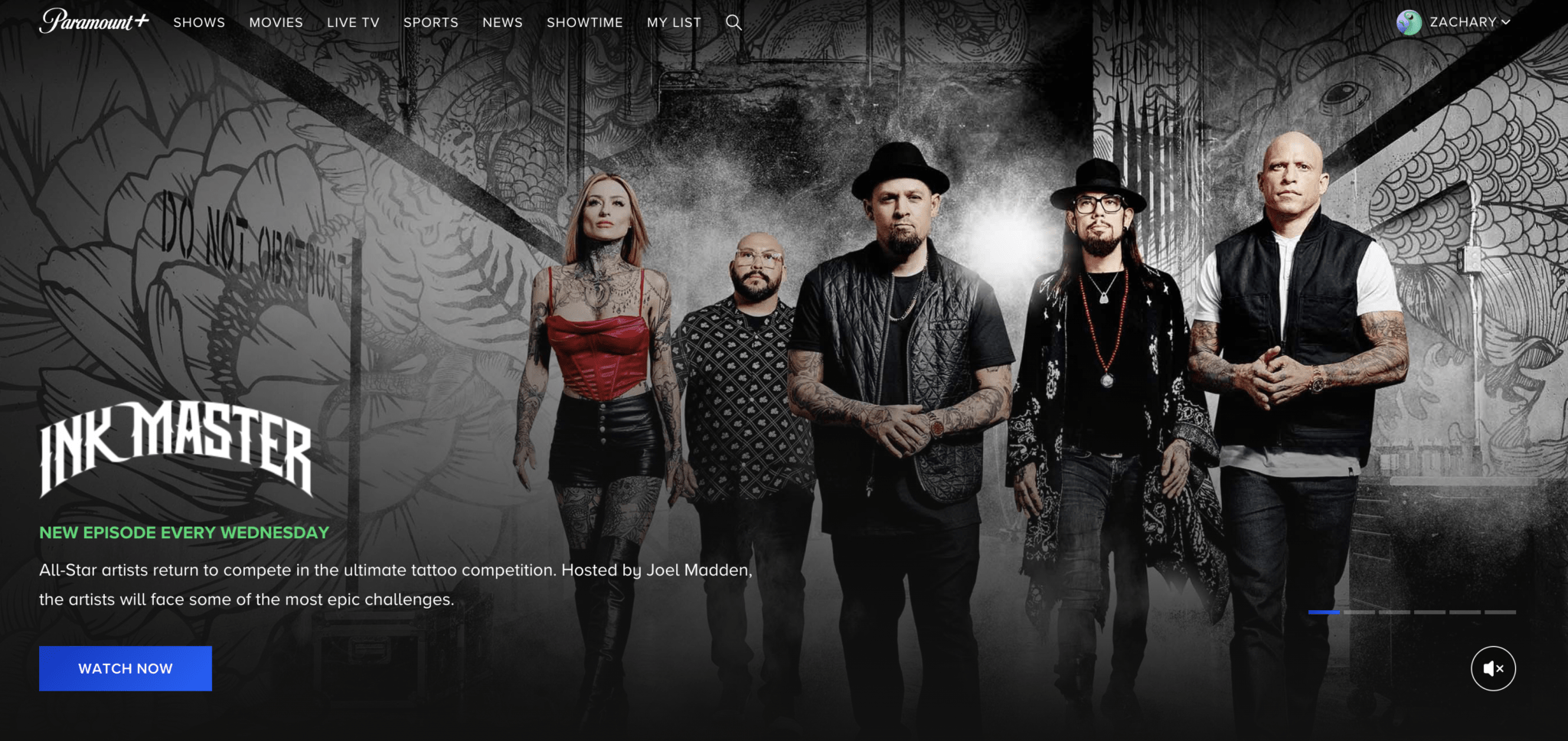 a group of people walking in front of a wall with tattoos