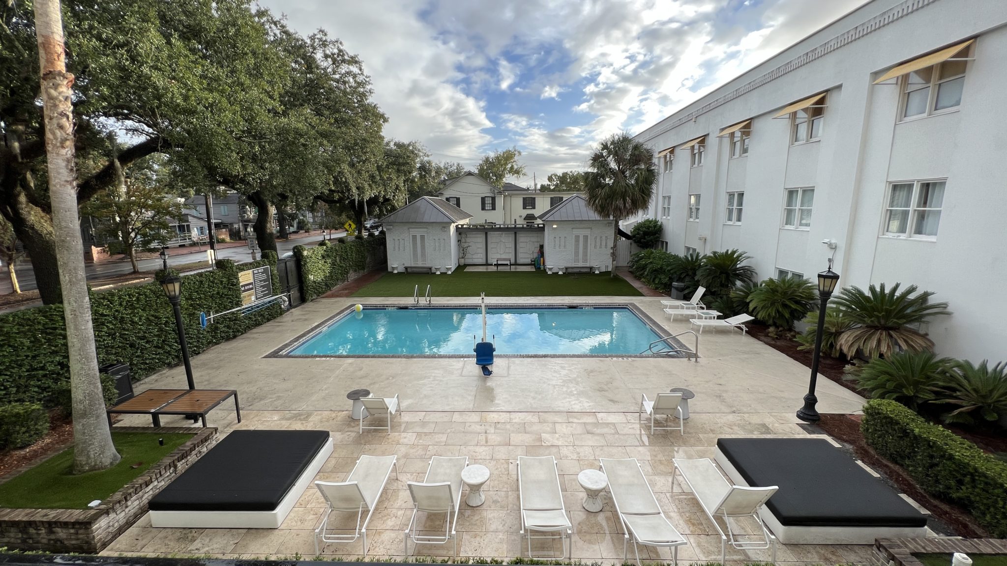 a pool with chairs and a building in the background