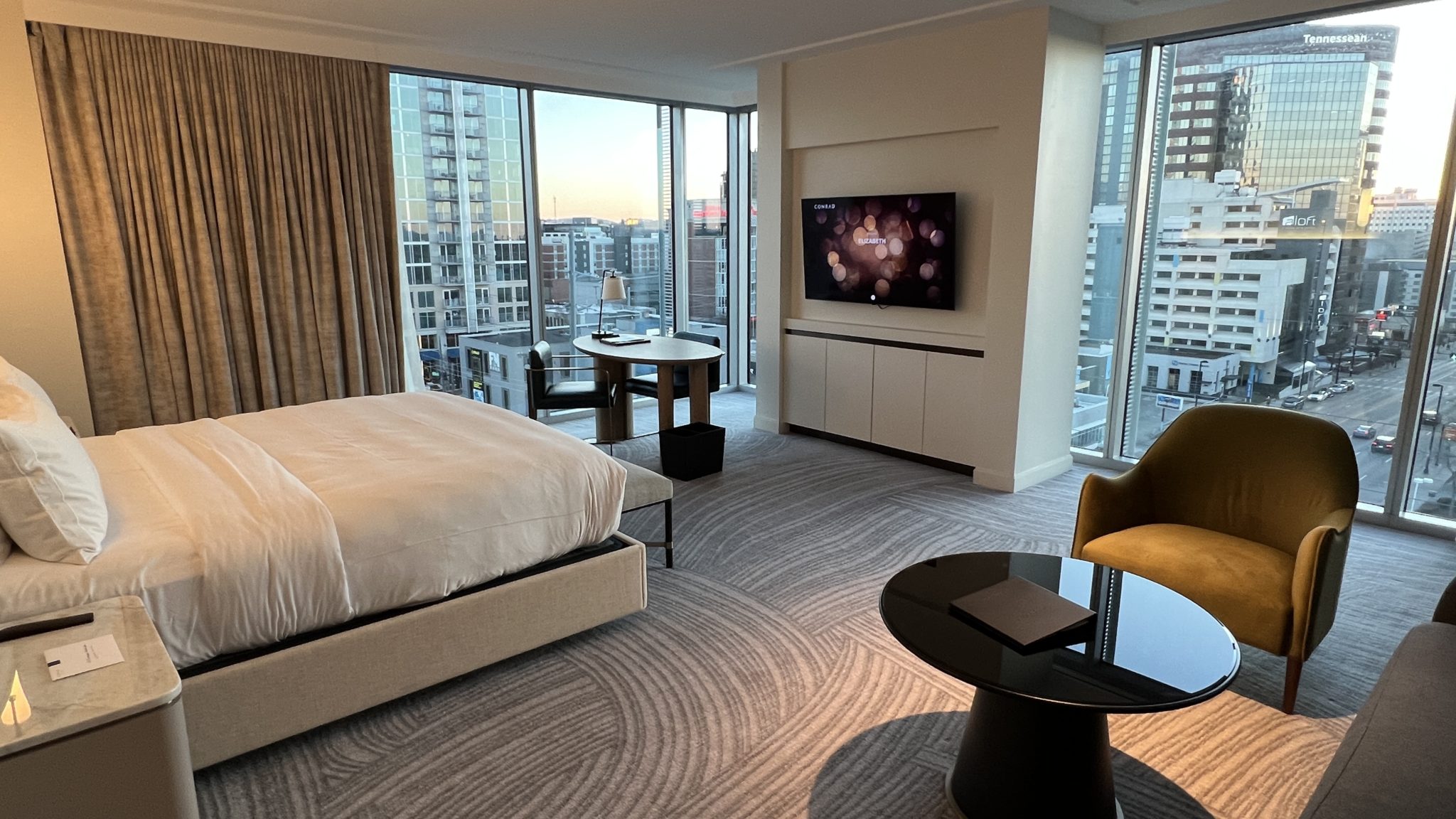a room with a bed and a table and a television