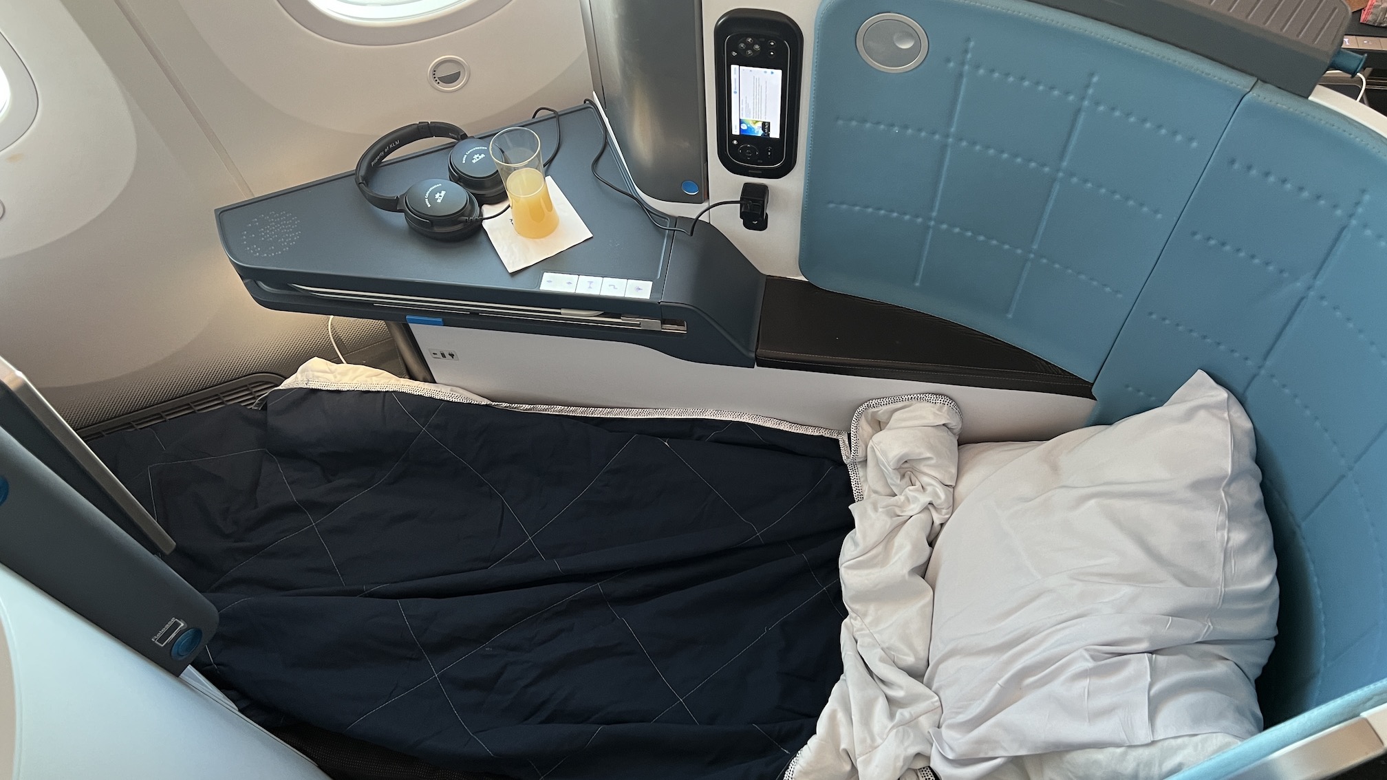 a bed with headphones and a drink on it