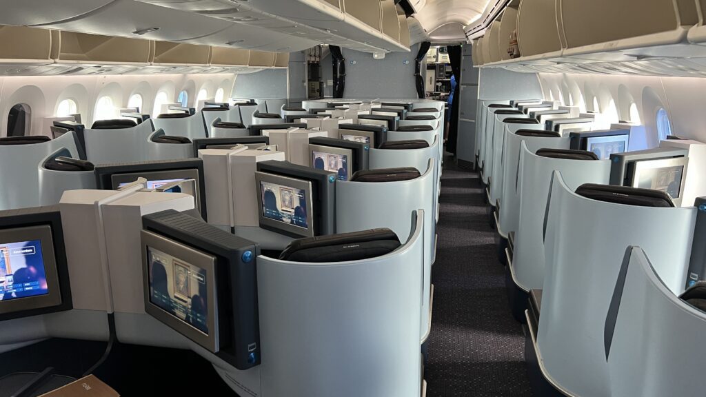 a row of seats with monitors on the side