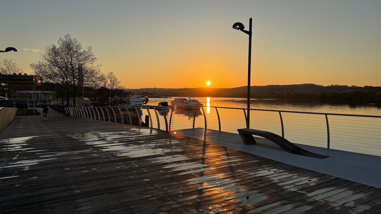 a dock with a body of water and a boat in the distance