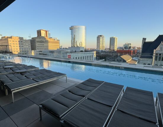 a pool with chairs and a city skyline