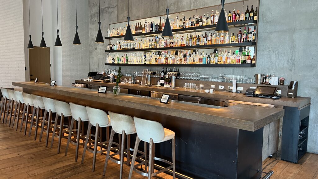 a bar with shelves of bottles and lights