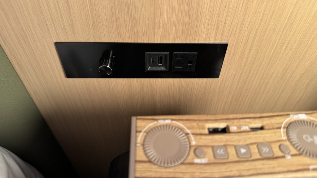 a black rectangular object with a knob and a wood panel