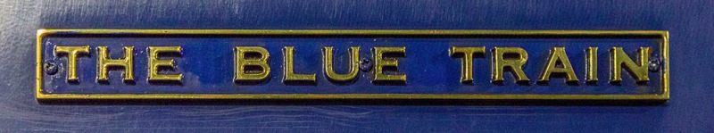 a blue sign with gold letters