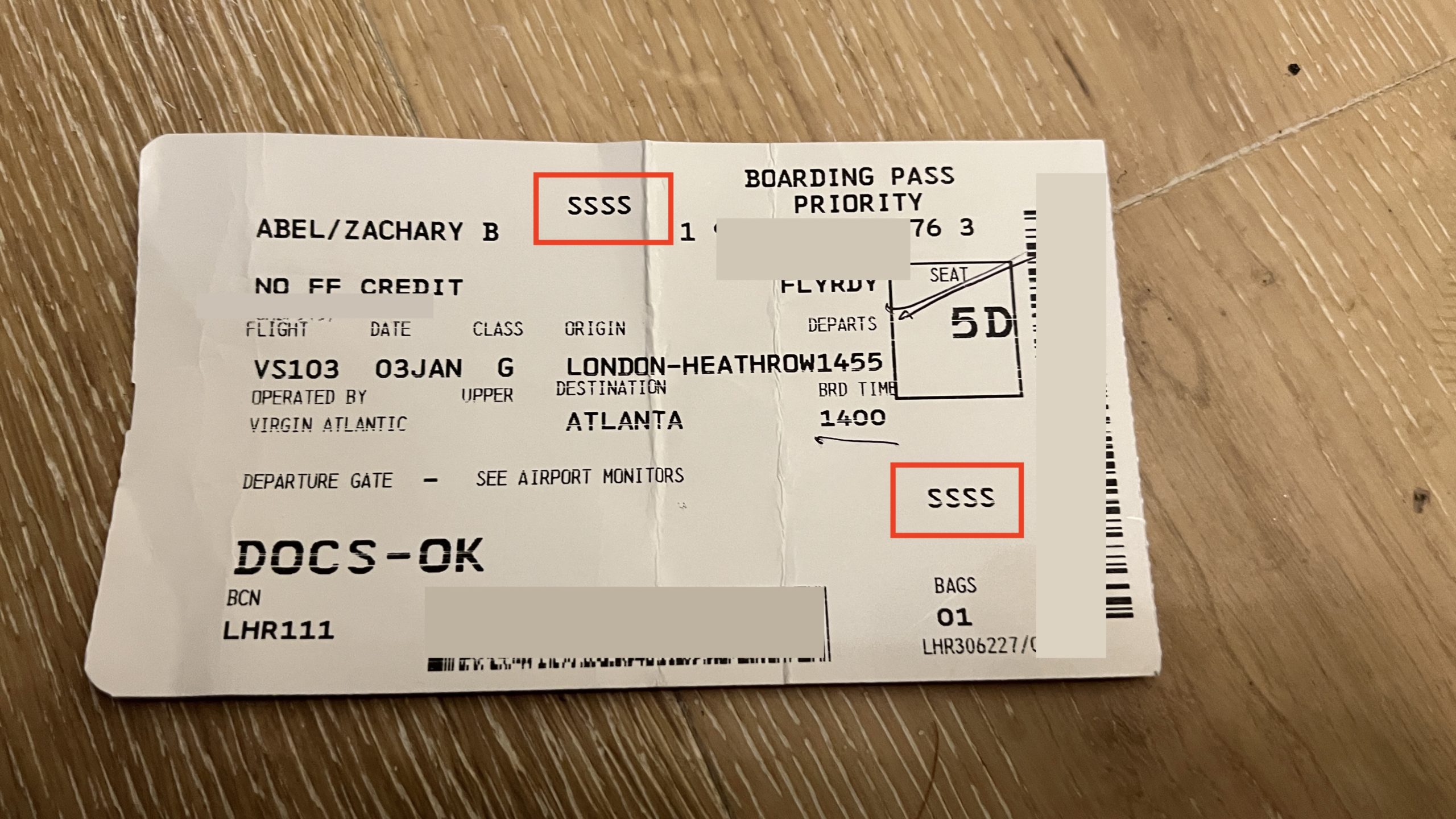 a white boarding pass with red text and numbers