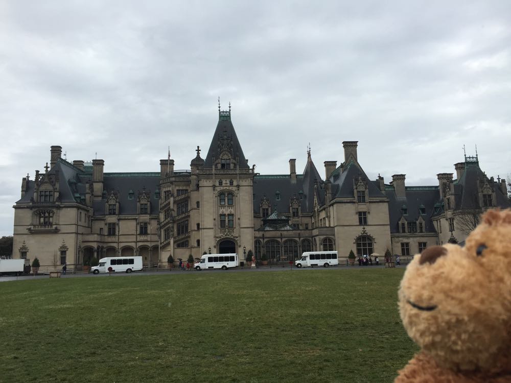 a stuffed animal in front of a large building with Biltmore Estate in the background