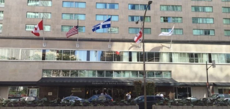 flags flying in the air in front of a building