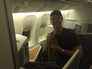 a man holding a stuffed animal in an airplane