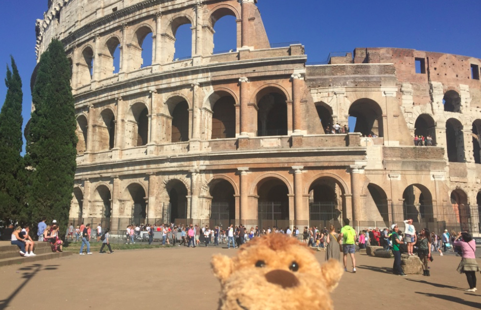 a stuffed animal in front of a large stone building