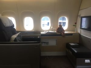 a teddy bear sitting on a window seat in an airplane
