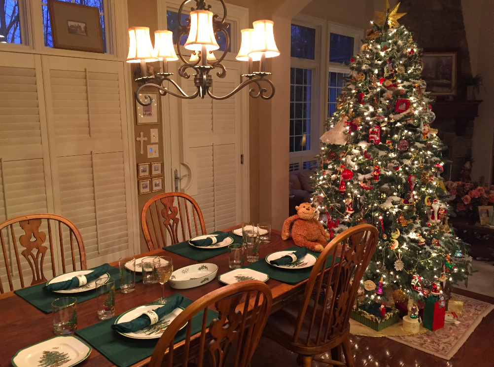a christmas tree with lights and a table set with plates
