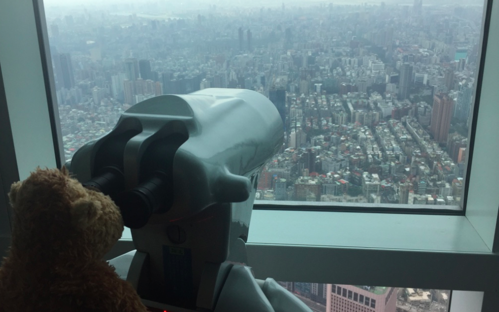 a teddy bear looking through a telescope