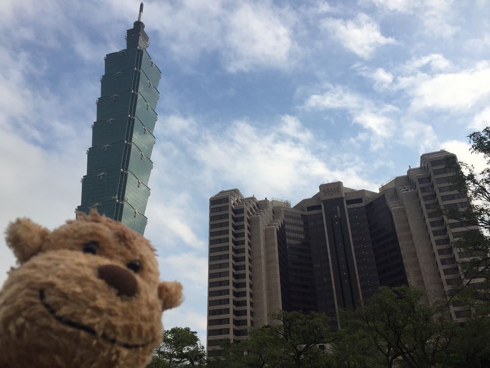 a stuffed animal in front of a tall building