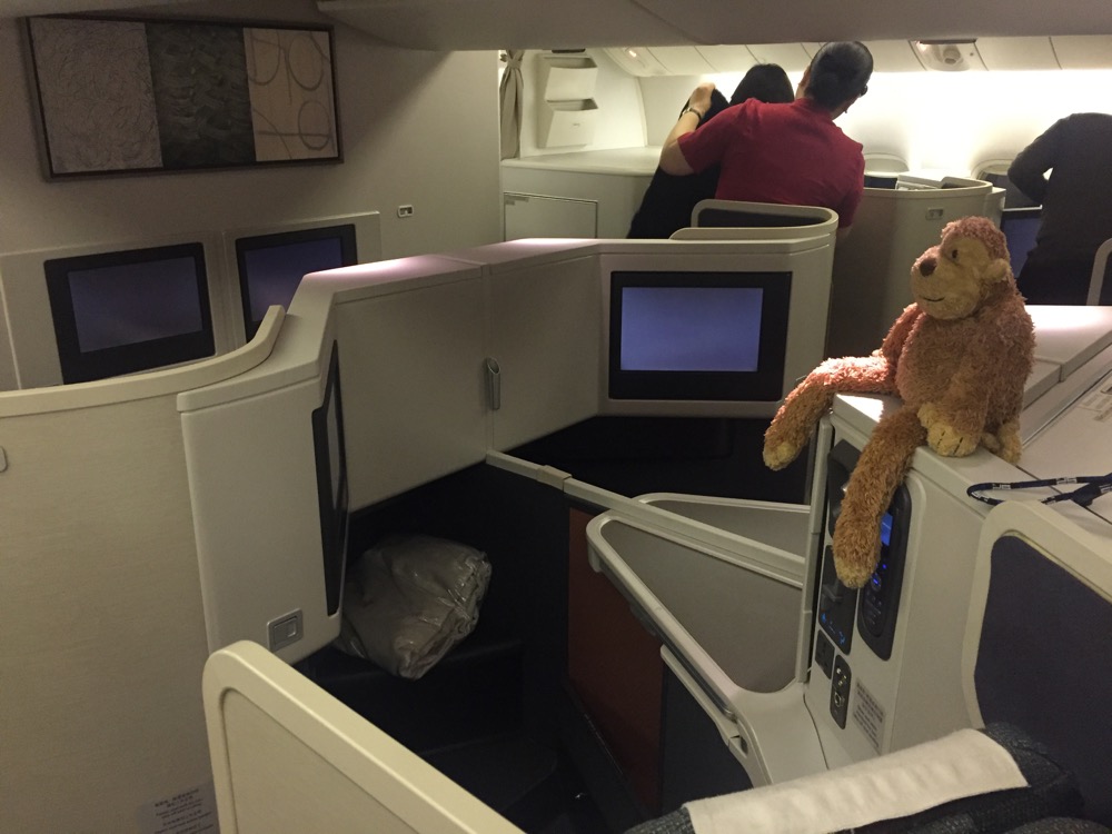 a teddy bear sitting on a desk in an airplane