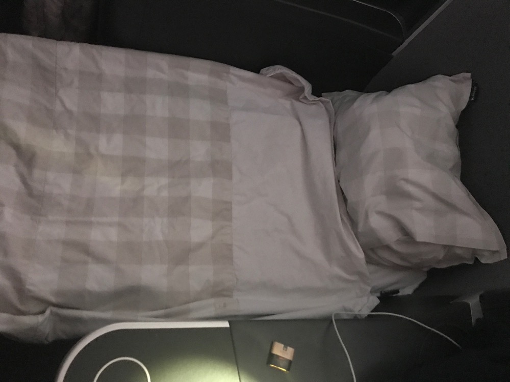 a bed with a pillow and a charger