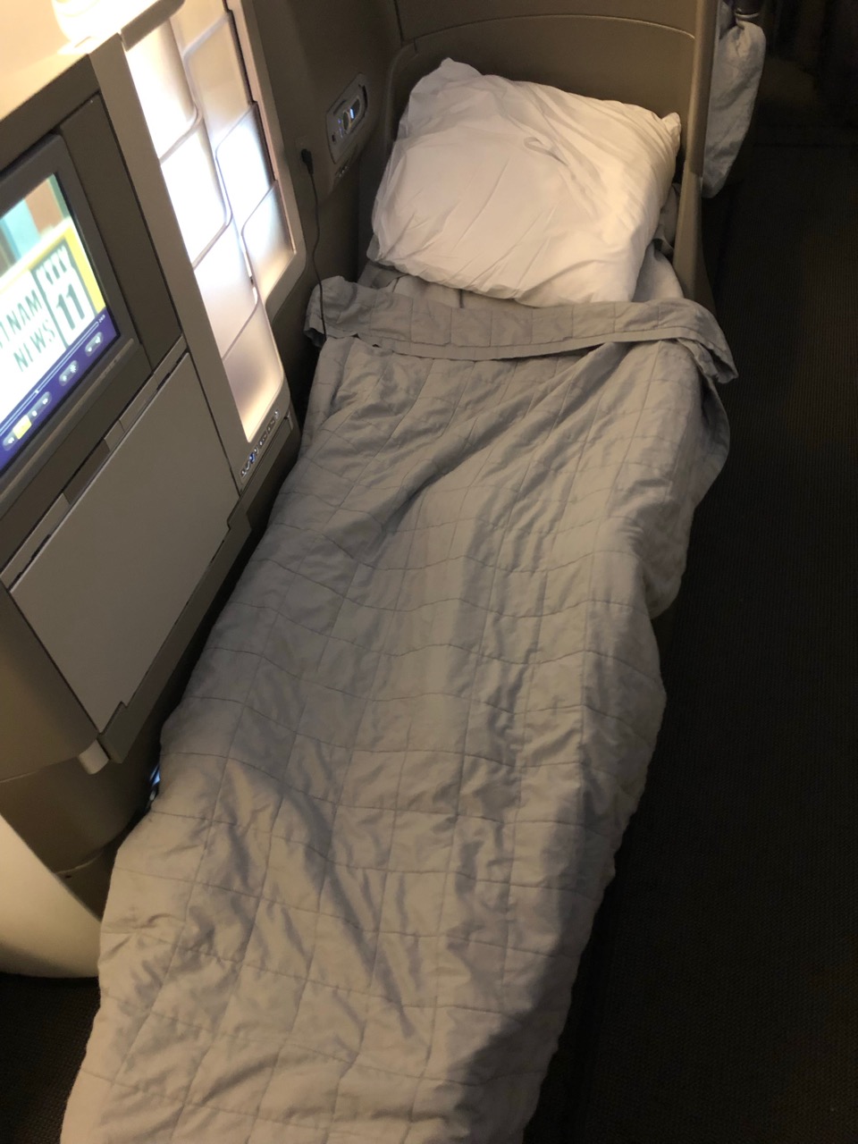 a bed with a pillow and a blanket on a plane