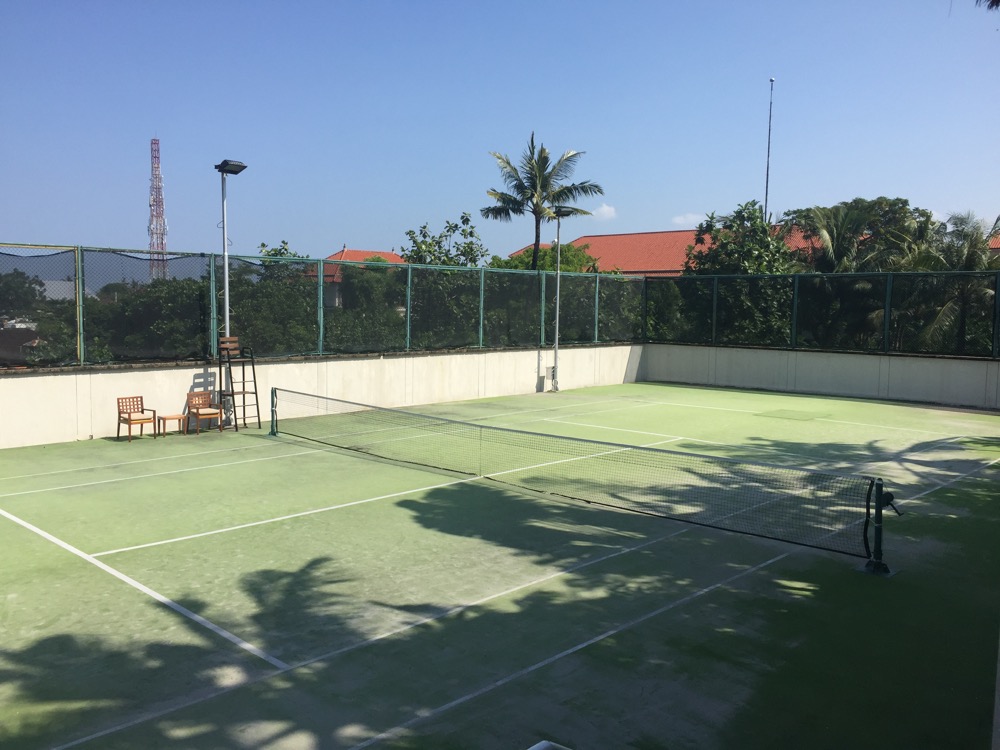 a tennis court with a net and chairs