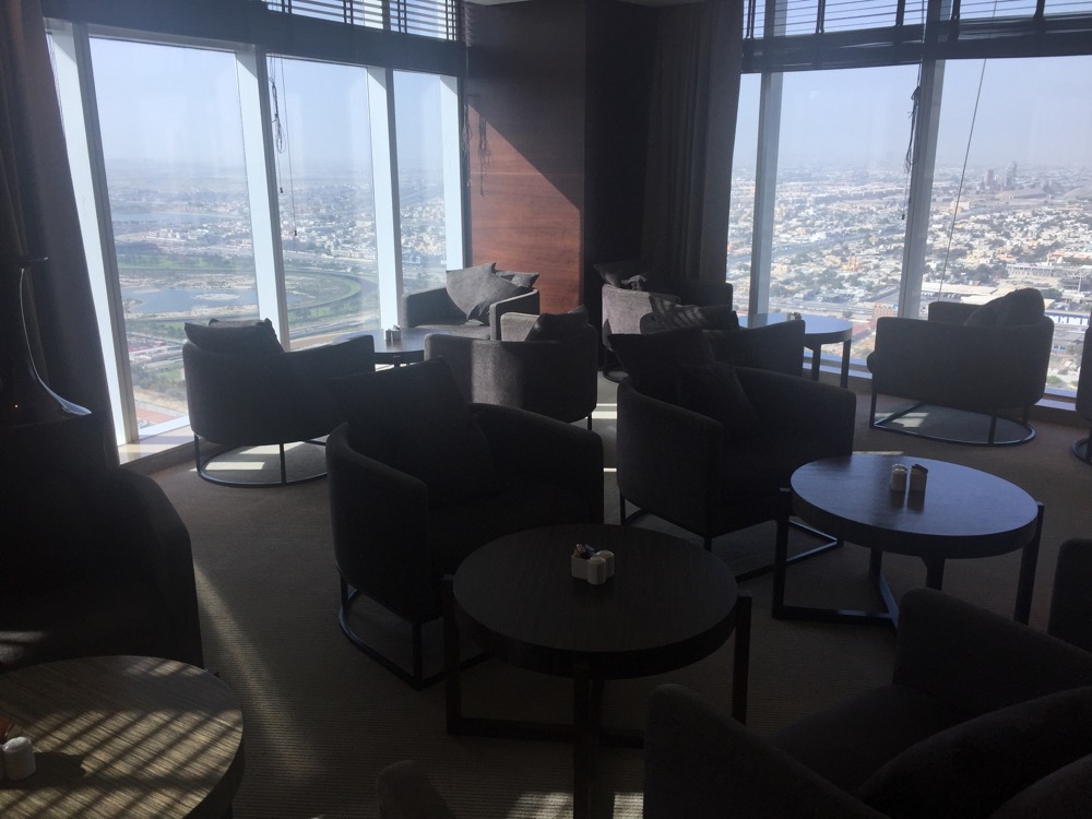 a room with chairs and tables and a view of a city