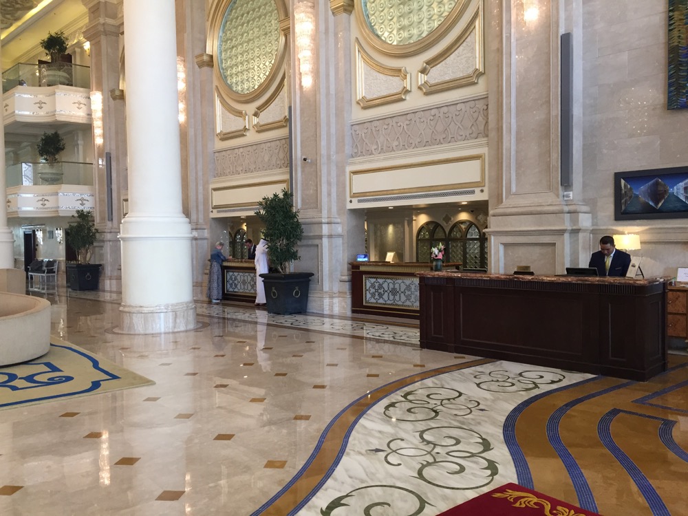 a large lobby with a marble floor and a large counter