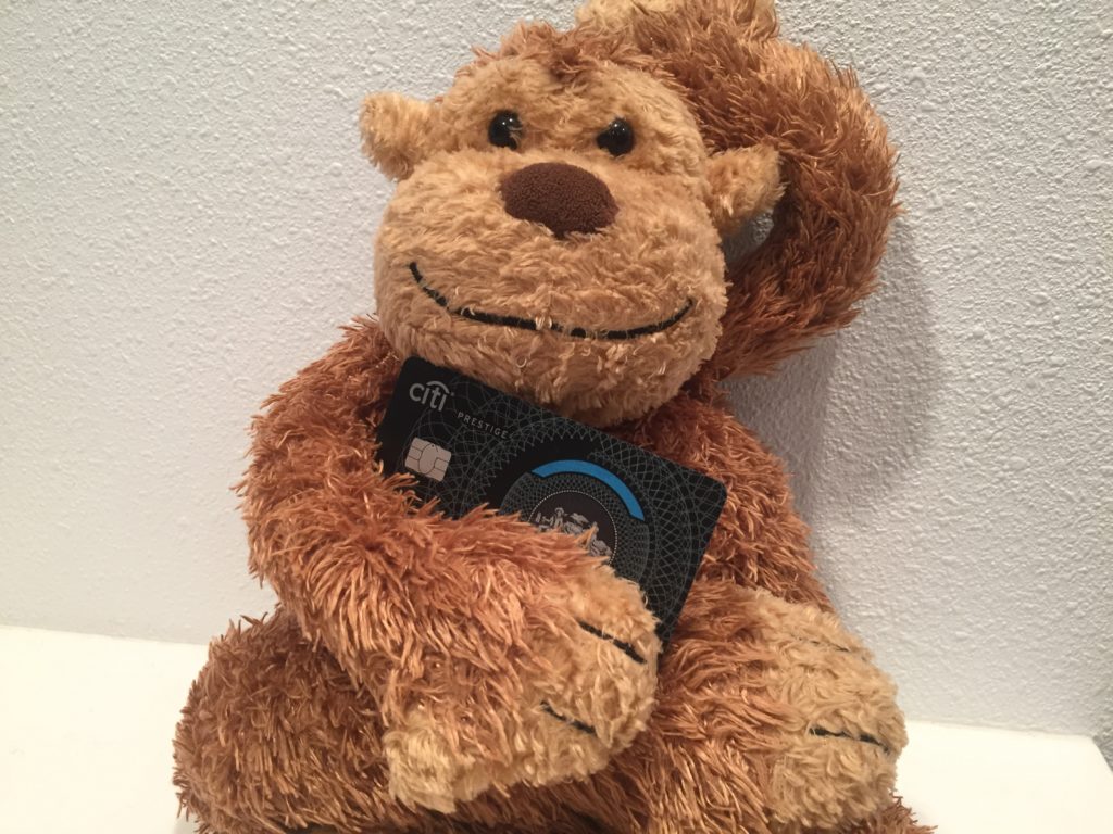 a stuffed monkey holding a credit card