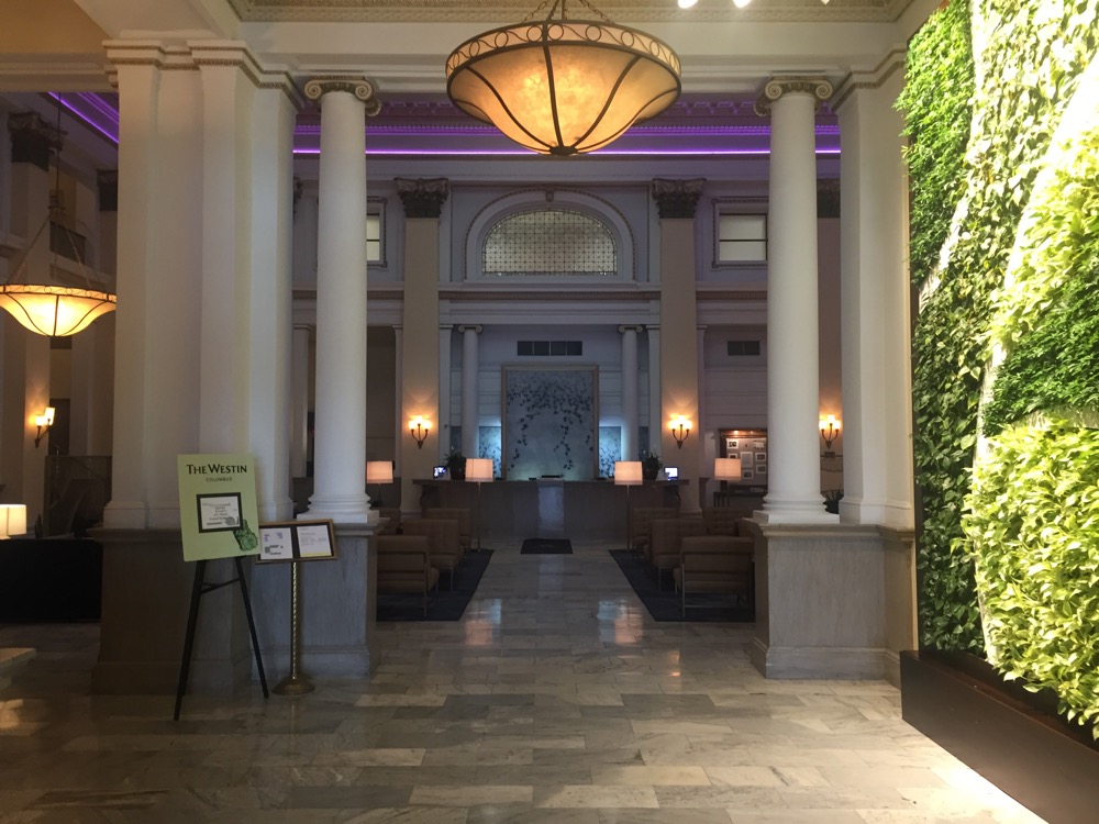 a lobby with a green wall and a light fixture